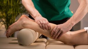 il massaggiatore effettua il massaggio al polpaccio ad un cliente ottenuto con il marketing per massaggiatori